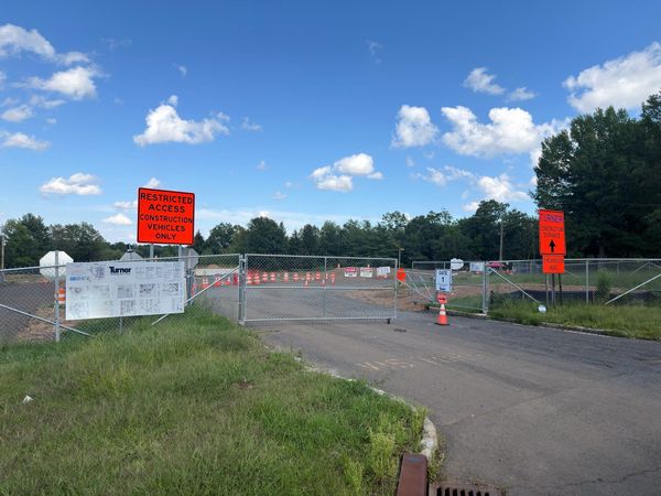 Gate 1 of the construction site on Mountainview Road in Warren Township, a chain link gate across the drive with orange barrels and Danger Restricted Area signs beyond.