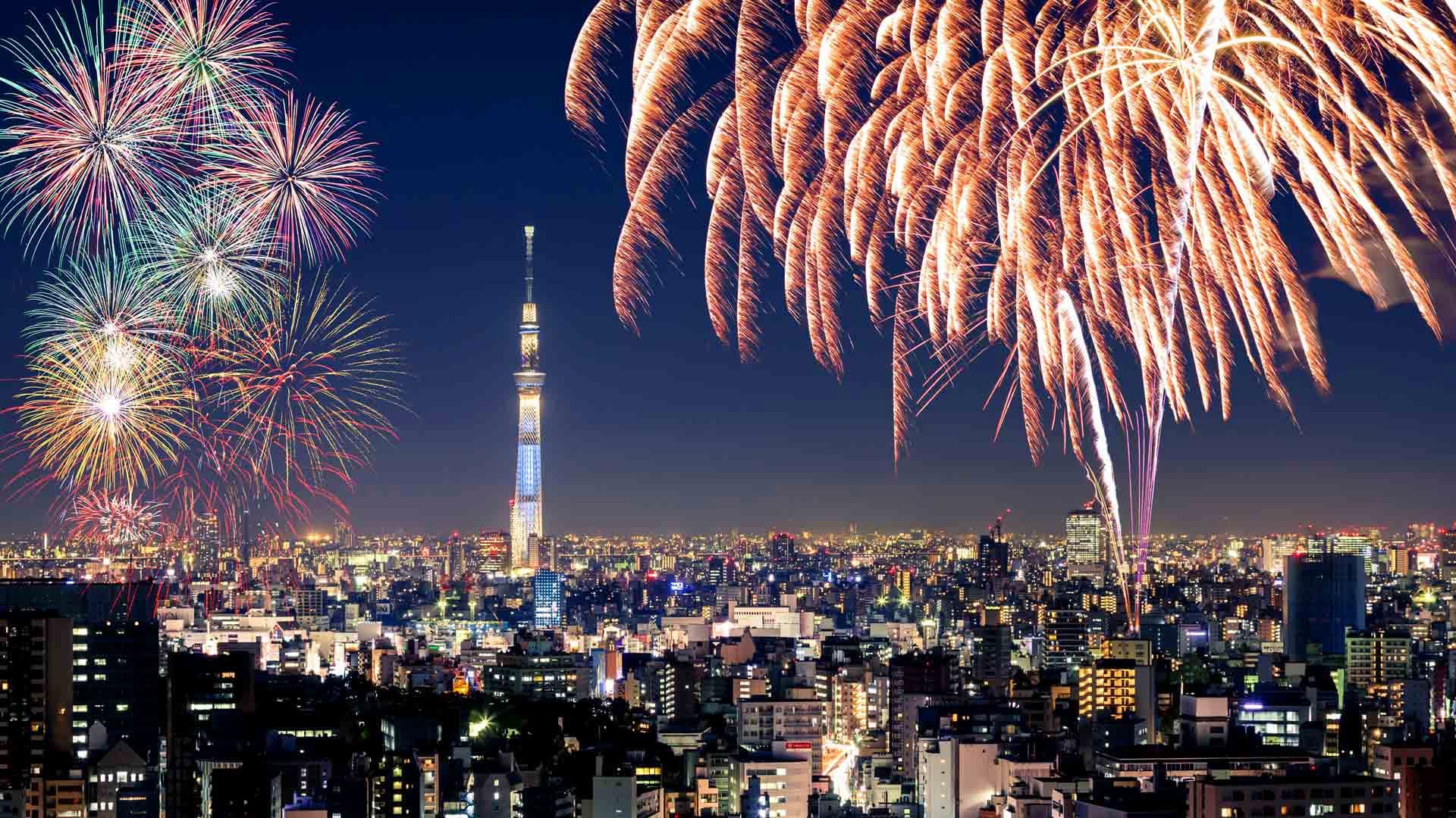 Fireworks in Tokyo during a summer festival at night, with the view of Tokyo Sky Tree