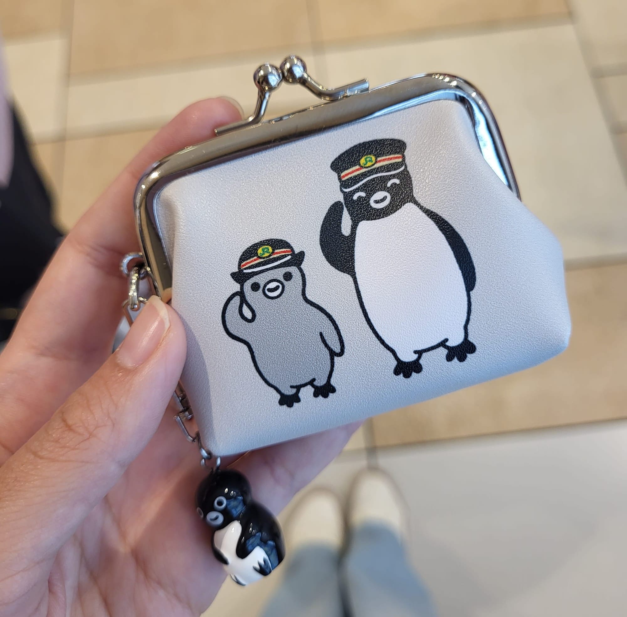 a girl holding a coin purse with a cute design in Tokyo, Japan