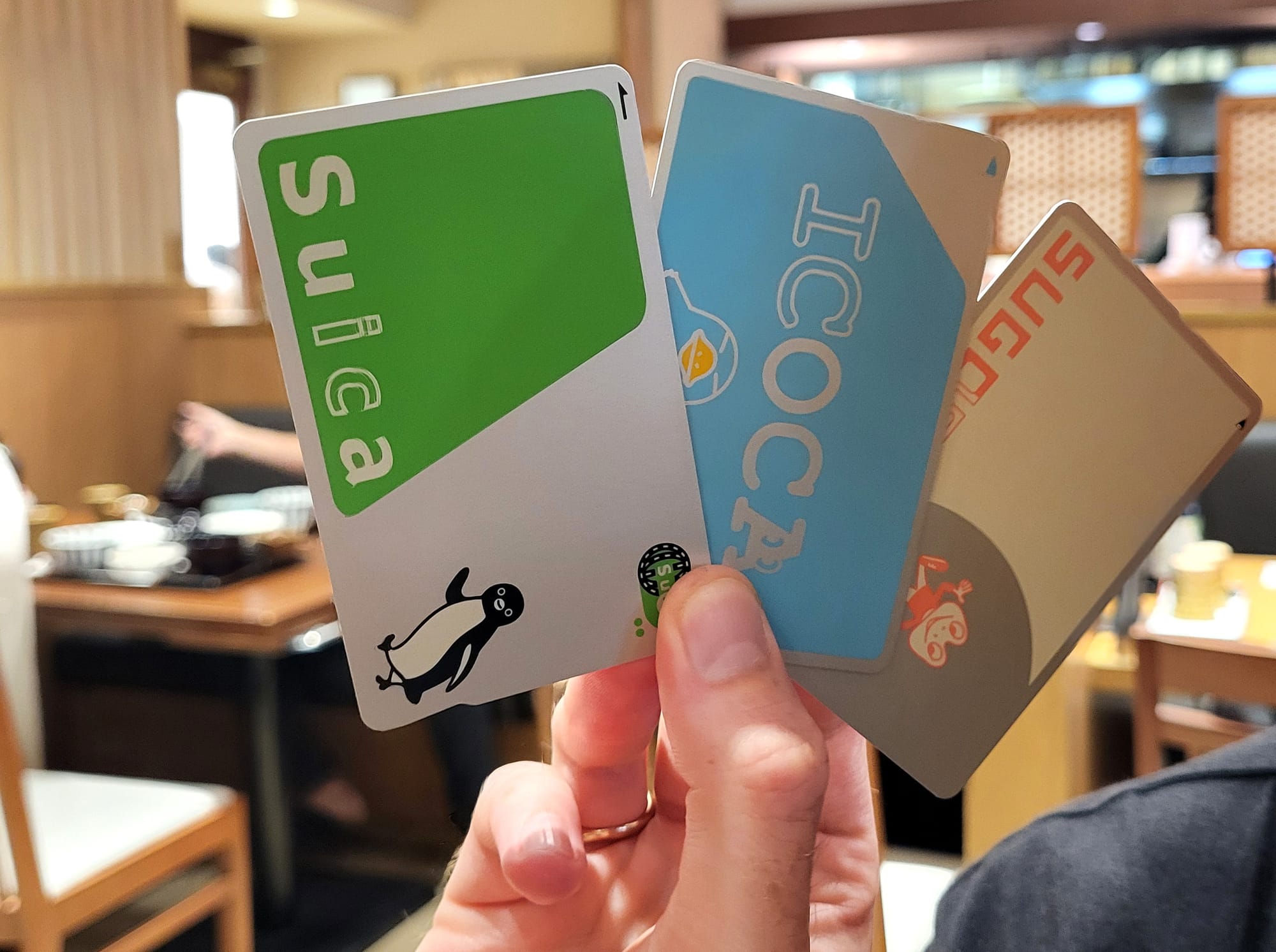 A man holding some Japanese IC cards for transportation and payments