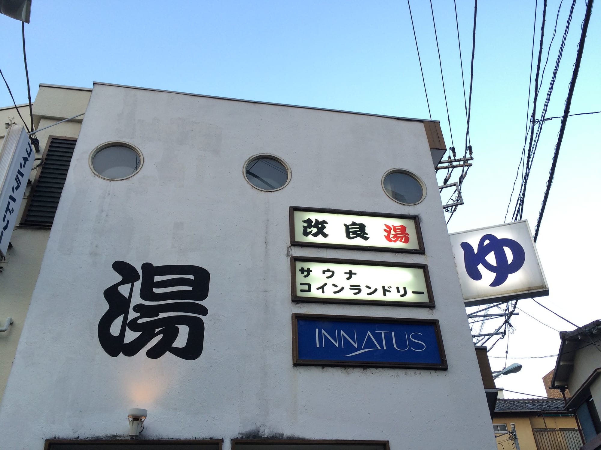 Kairyo-yu in Tokyo  with circular windows and multiple signs in Japanese.