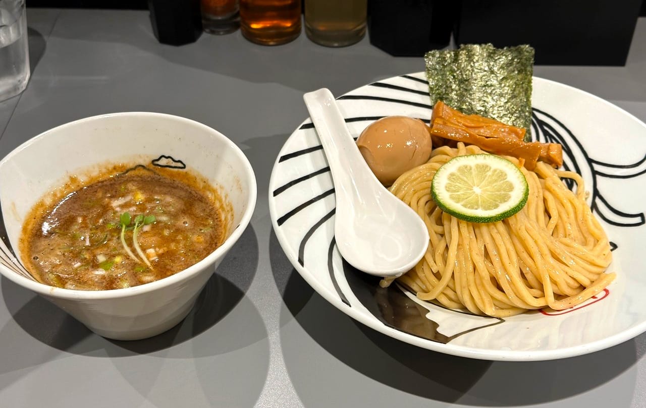 A picture of tsukemen, a bowl of noodles on the right and a bowl of hot soup on the left.