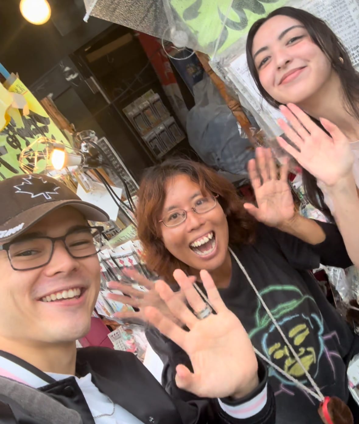 A Japanese young man and a girl saying hello to the camera next to a local Japanese woman in Tokyo, Japan.