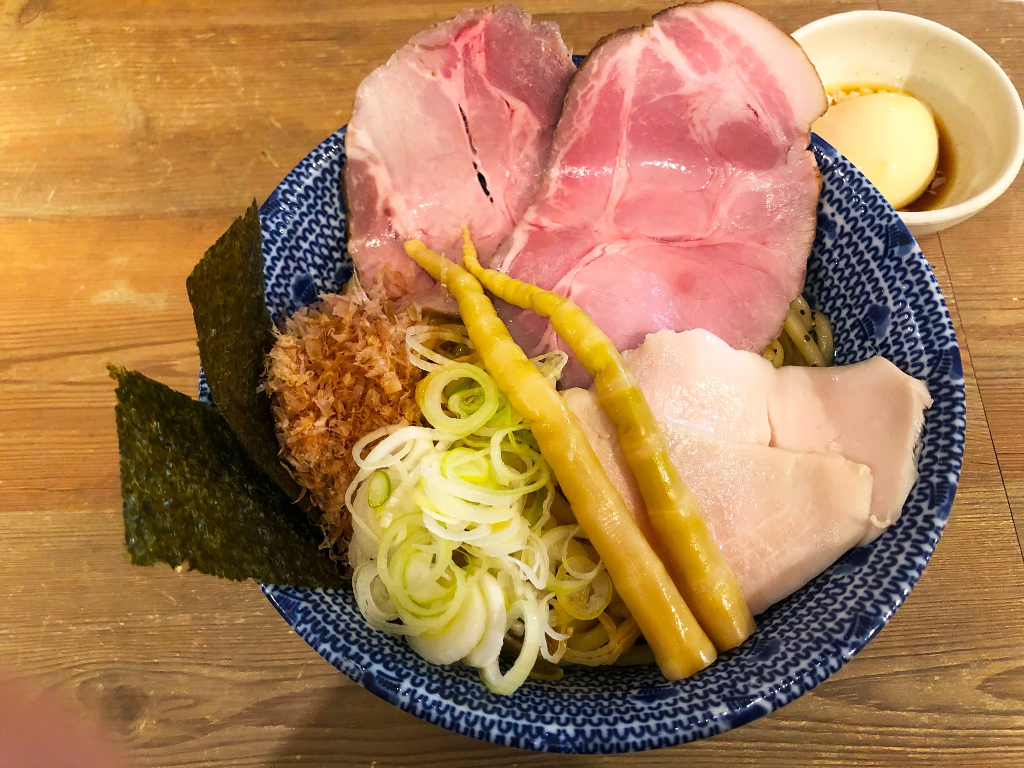 A photo of the abura soba in Tokyo. Bowl of ramen with meat, scallions, and bamboo shoots.