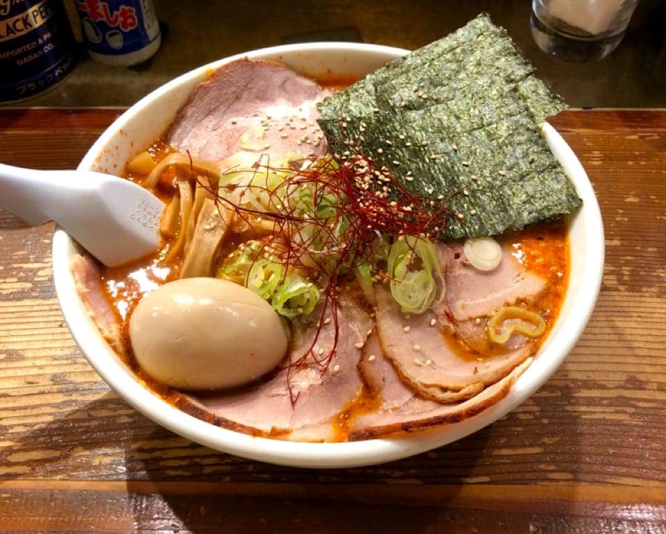 A big bowl of ramen with egg, meat and seaweed