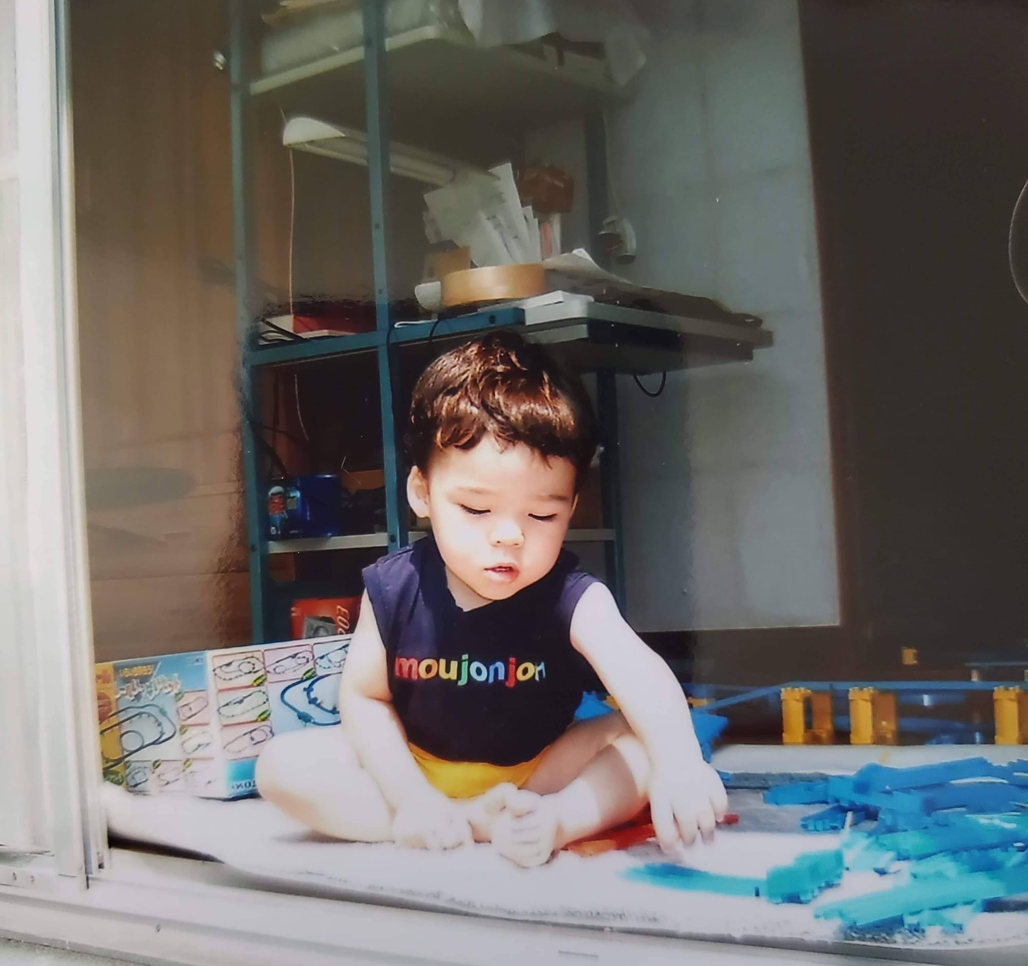 A small kid playing with toys at a Japanese house.
