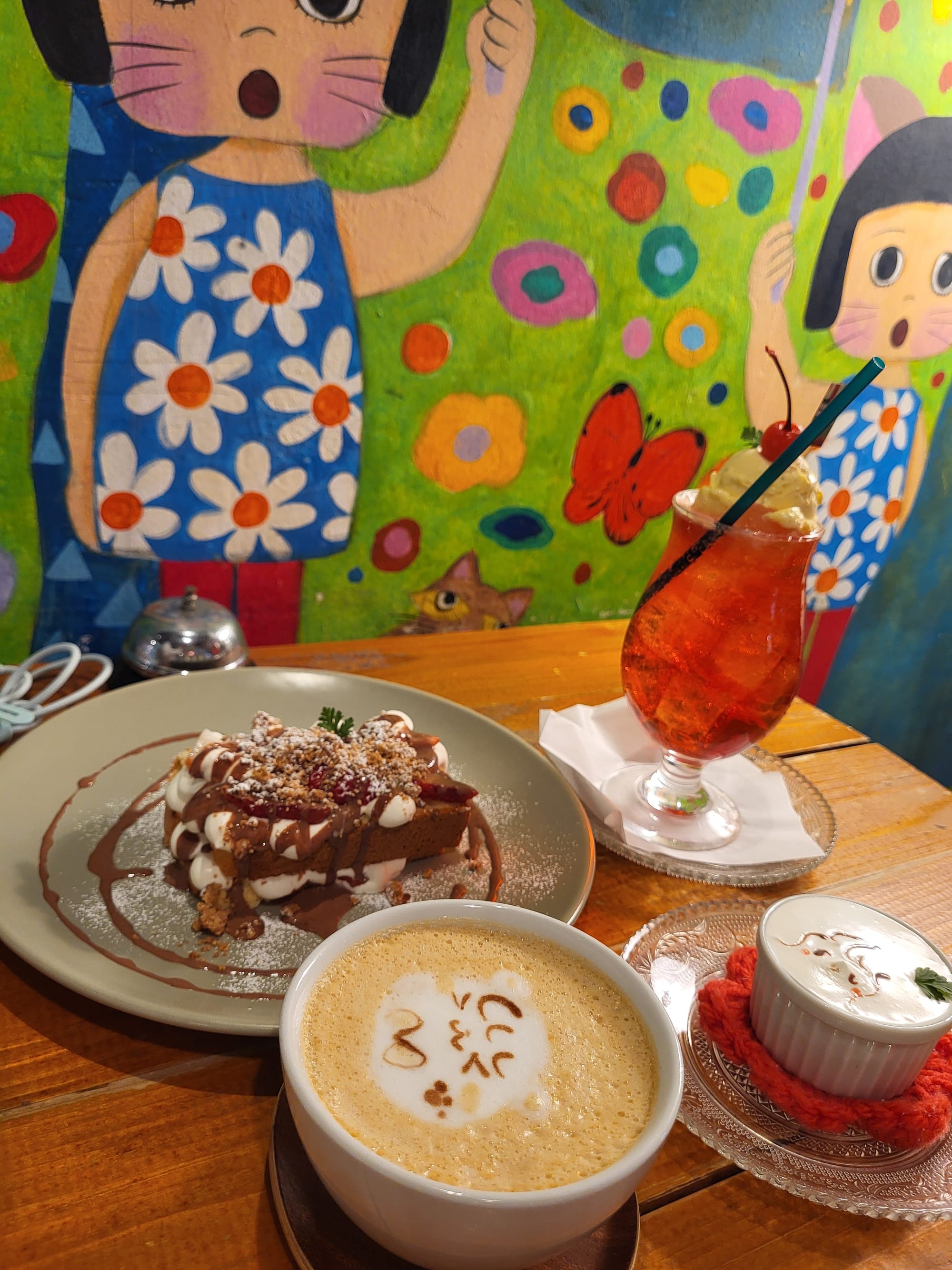 A picture of some colorful drinks, sweets and coffee with cute decorations at a cafe in Tokyo.