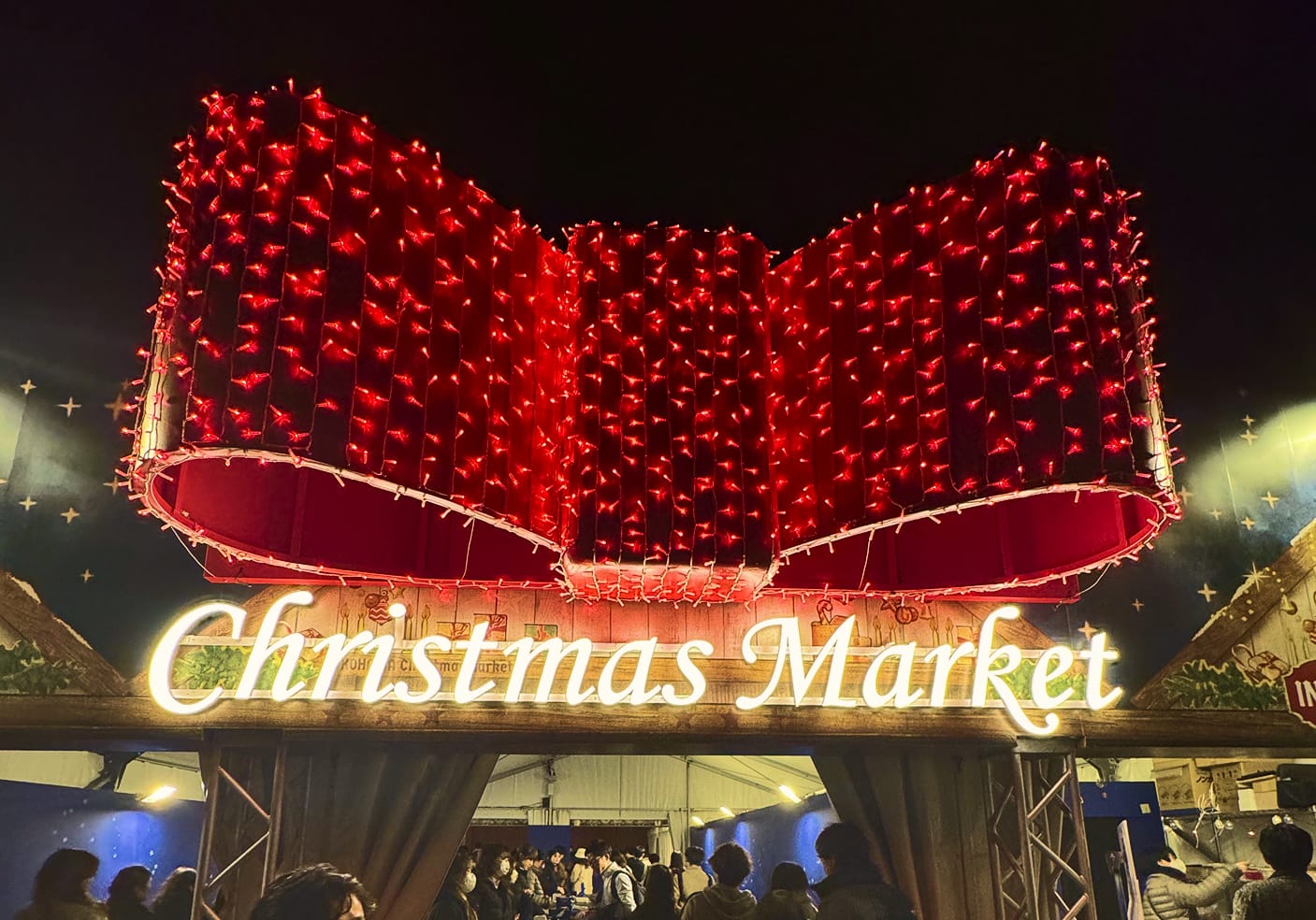 The entrance to a Christmas Market that has large boy lit with red lights