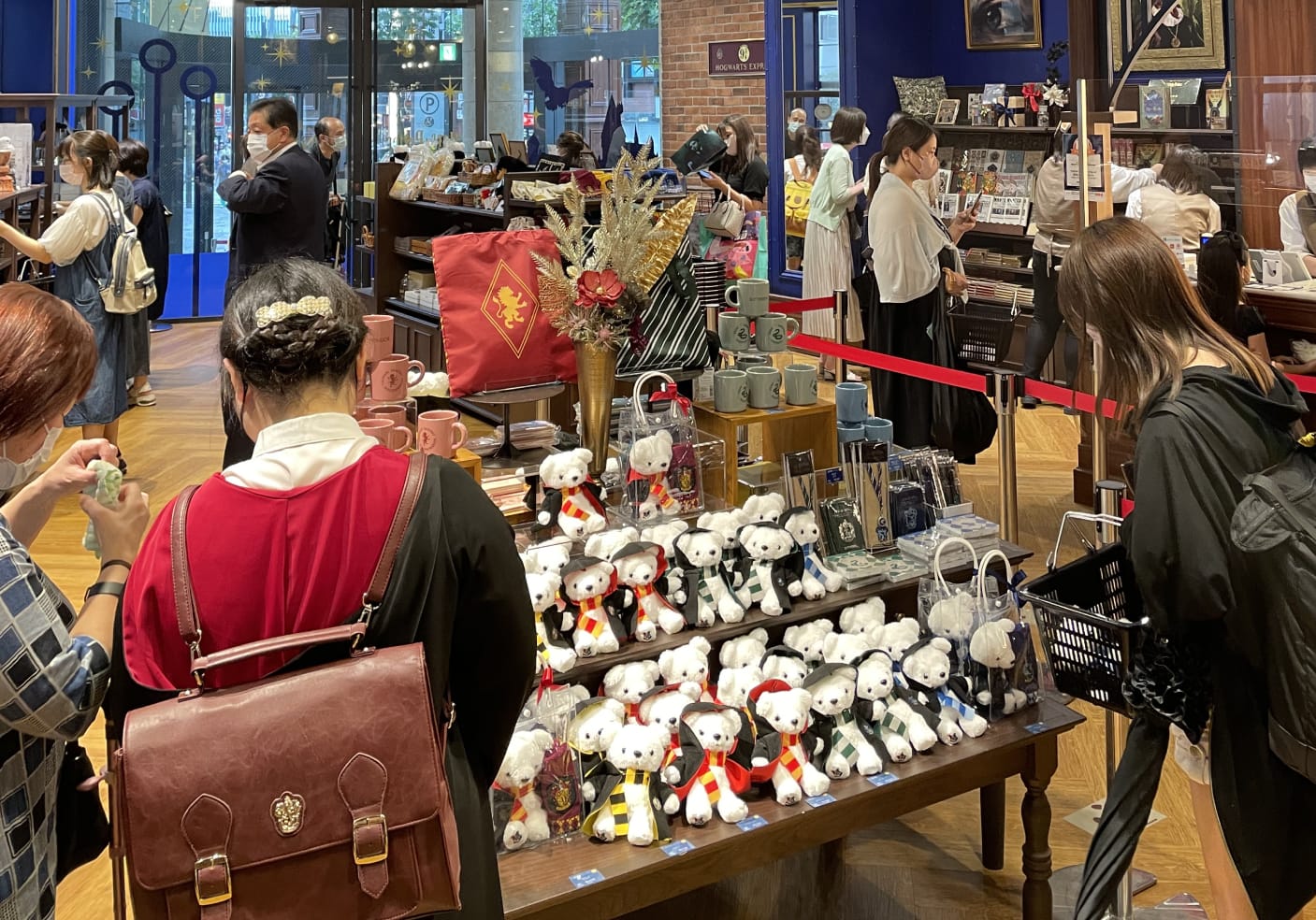 Interior of Harry Potter Mahou Dokoro store. Hogwarts House teddy bears and mugs are sitting on a display table.