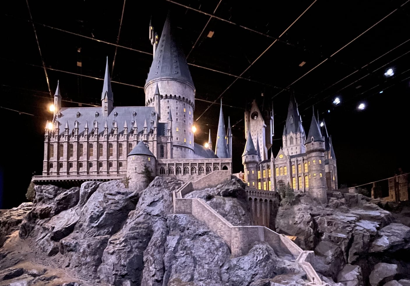 Model of Hogwarts Castle, dimly lit setting and mystical atmosphere.