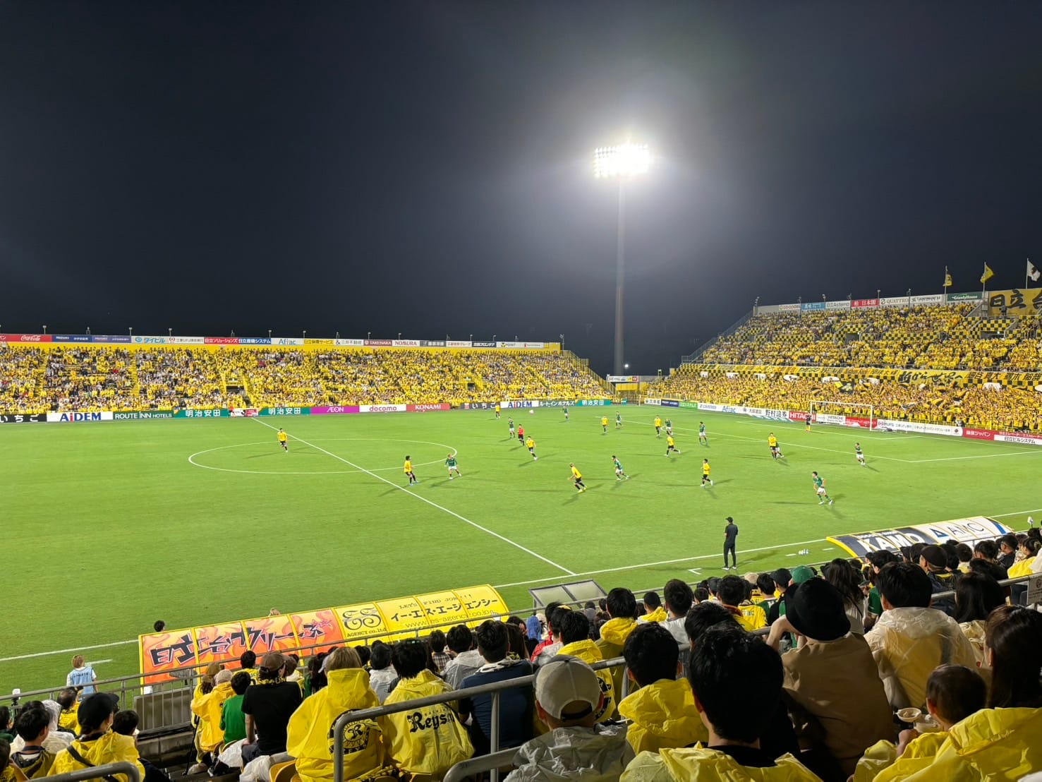 Soccer match at night in a crowded stadium.