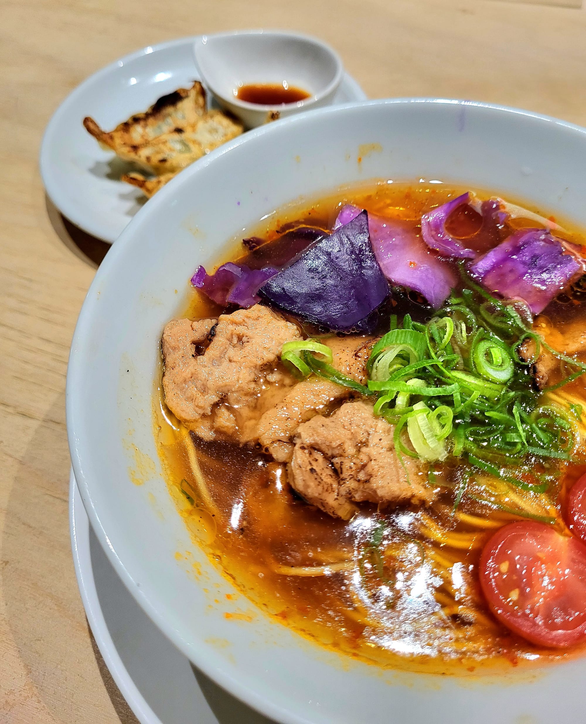 A bowl of vegan ramen at with vegan meat, vegetables, and gyoza at Vegan Bistro Jangara