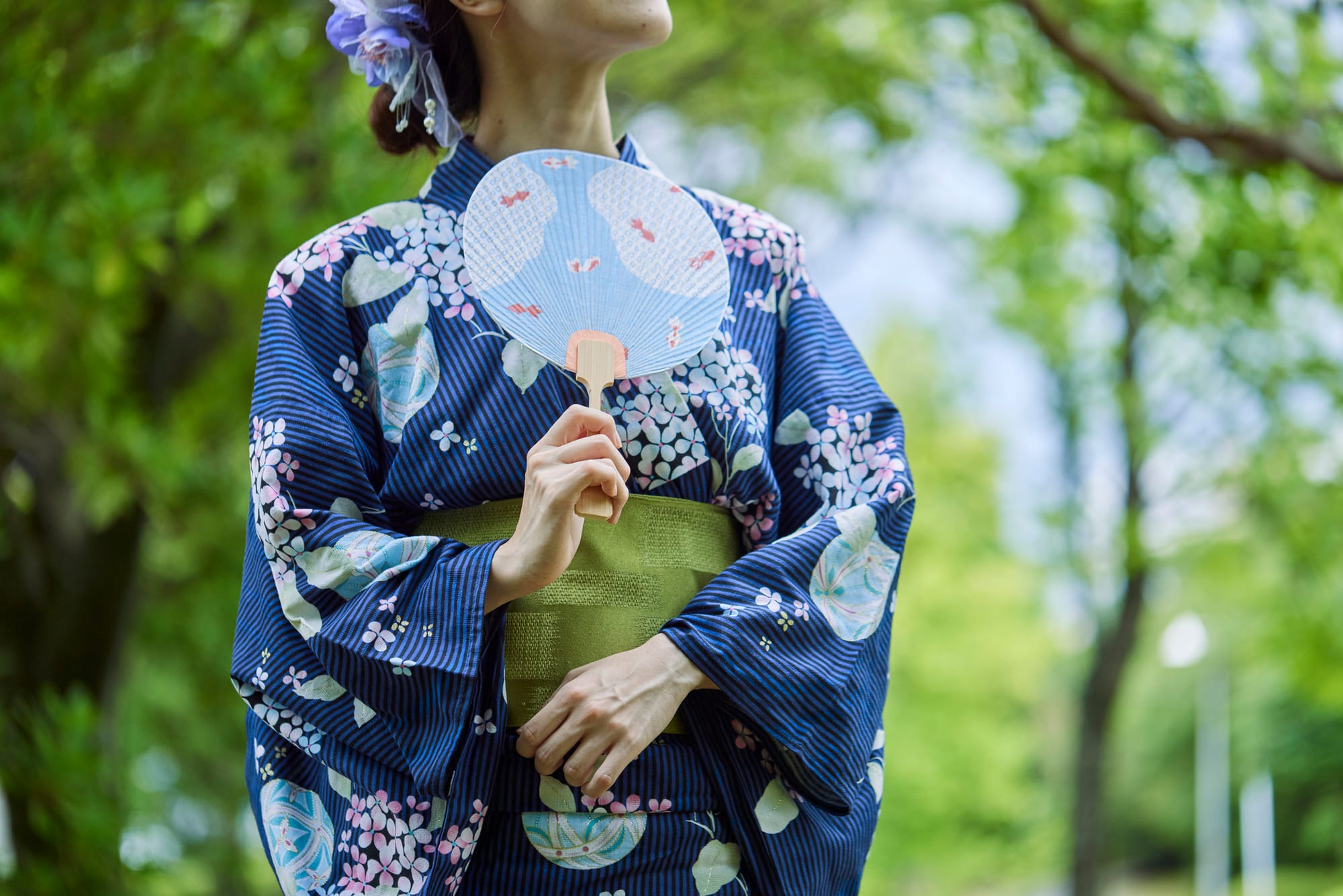 a Japanese woman wearing a yukata during summer in Tokyo, Japan, and holding a hand fan