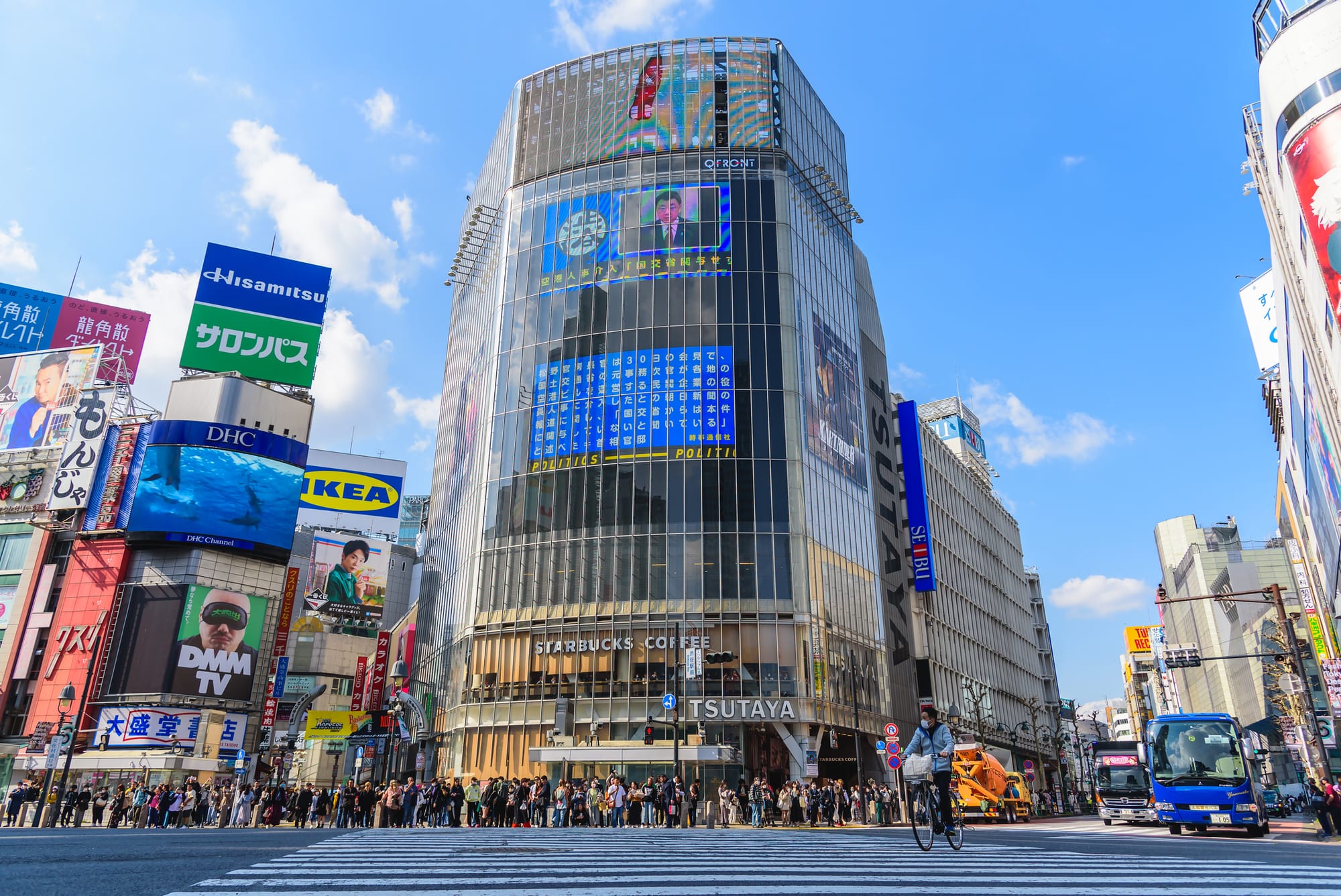Busy Shibuya crossing with crowds, cyclist on a zebra crossing.