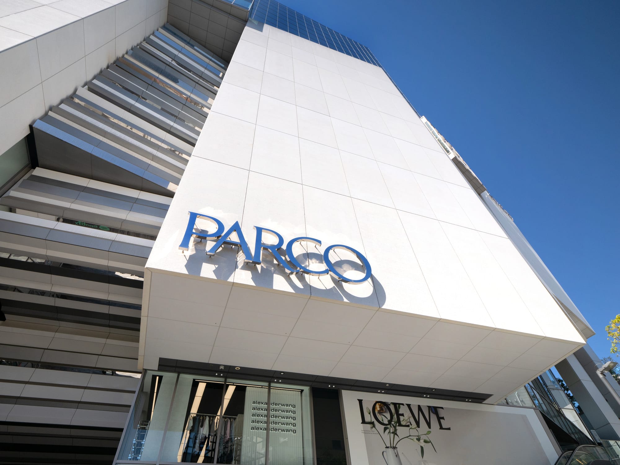 PARCO building, tall structure against clear blue sky.