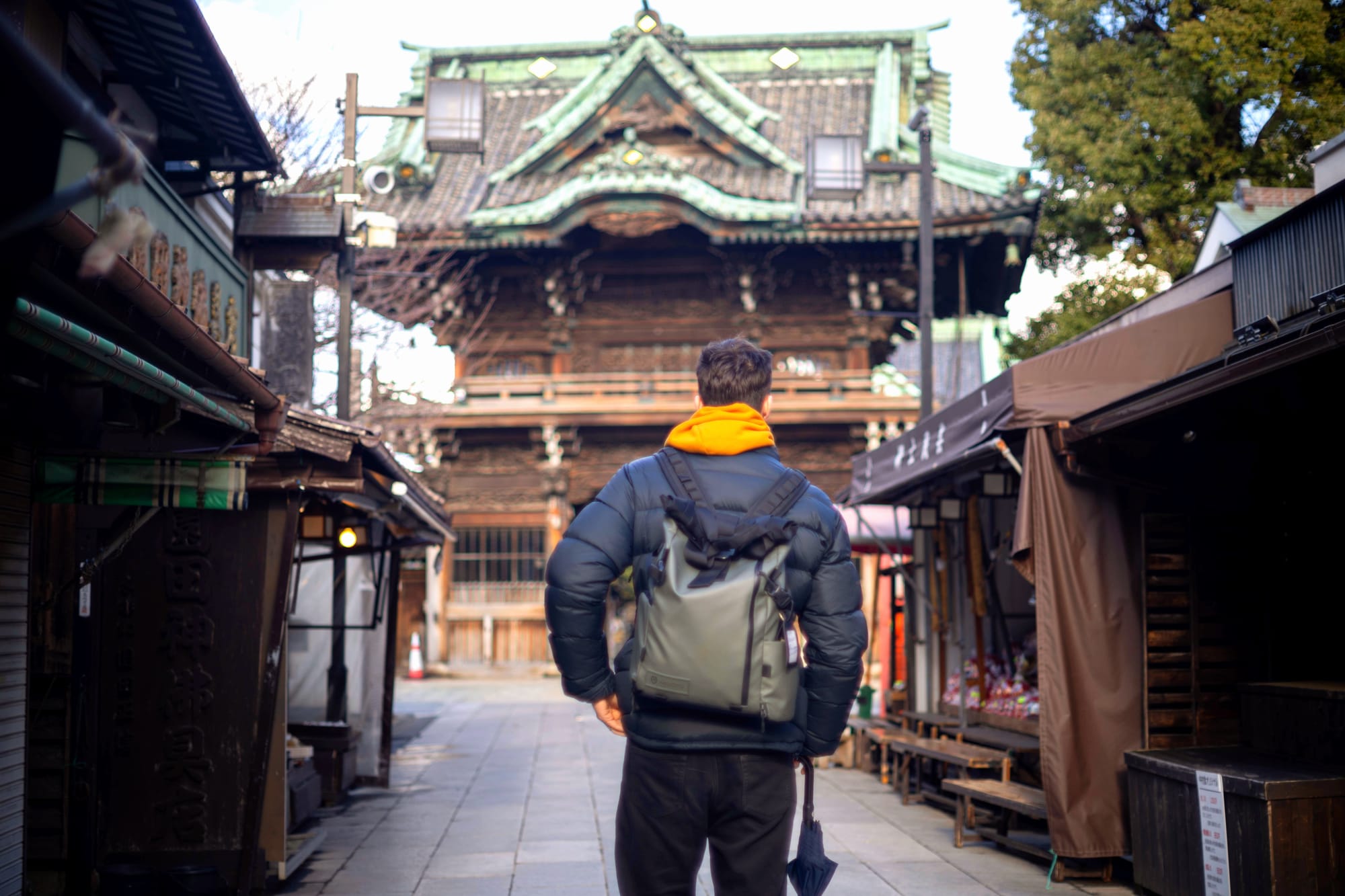 Young man standing in the main street in front of Taishakuten Temple