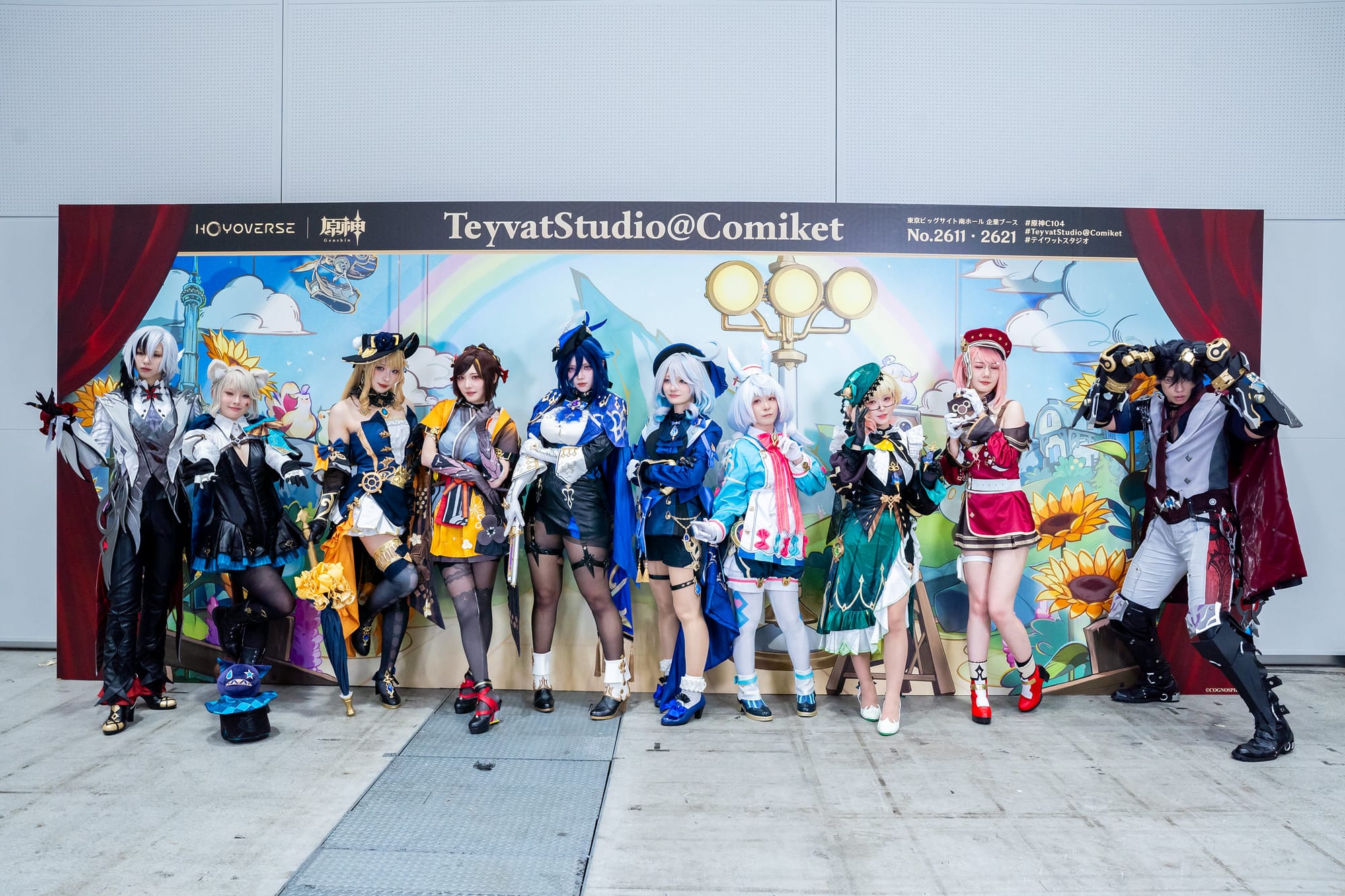 Cosplayers in vibrant outfits pose in front of a colorful backdrop 