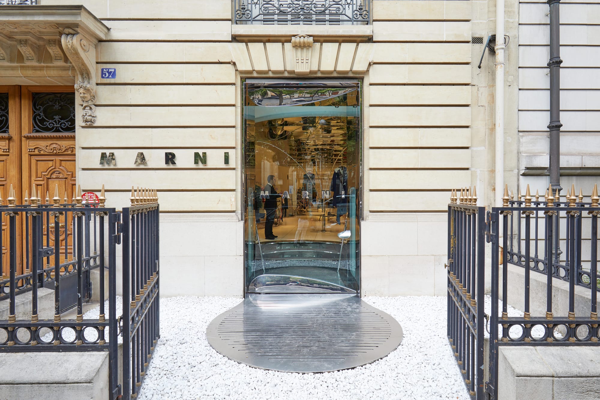 Elegant storefront with "MARNI" sign on beige building.
