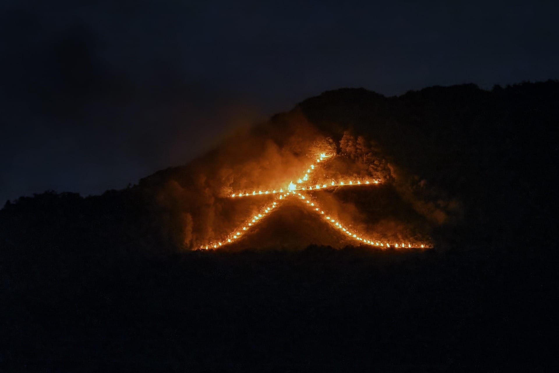 A series of ritual bonfires arranged to look like the kanji character "dai" (meaning "big") on a mountain for Kyoto's Gozan no Okuribi, also known as the Daimonji Festival