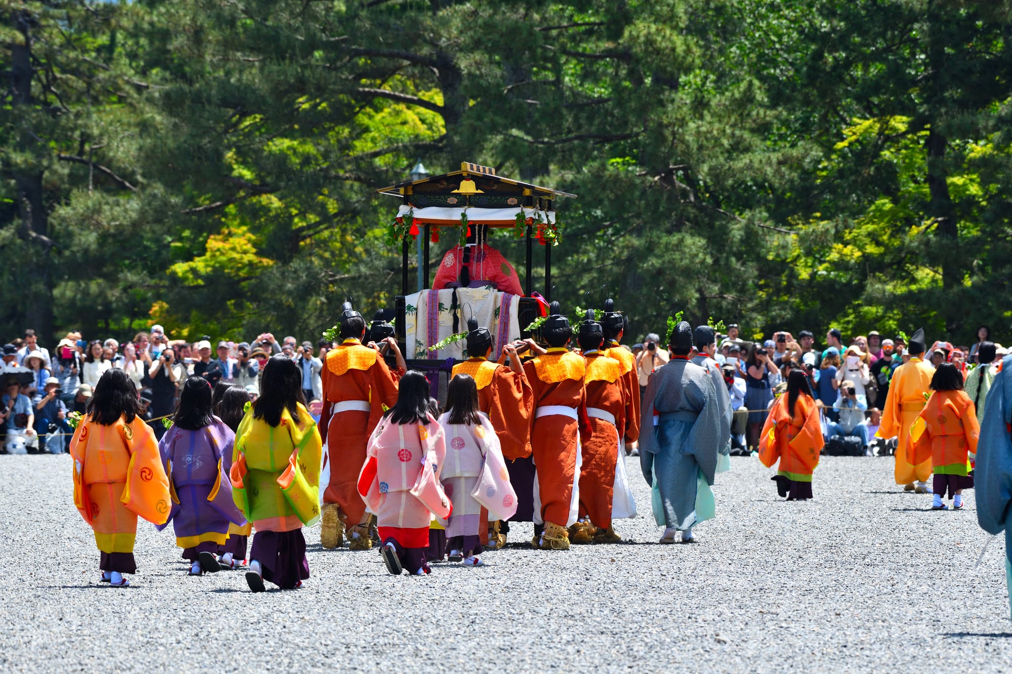 A procession of children following behind a float during the Aoi festival in Kyoto.