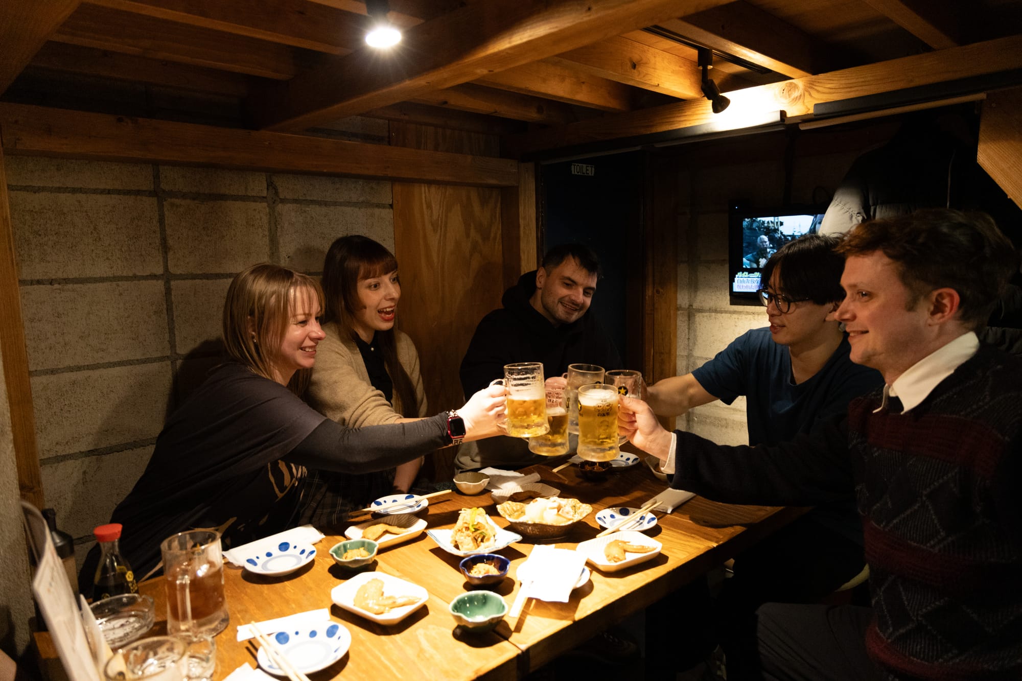 A group of friends sharing a drink at a local izakaya