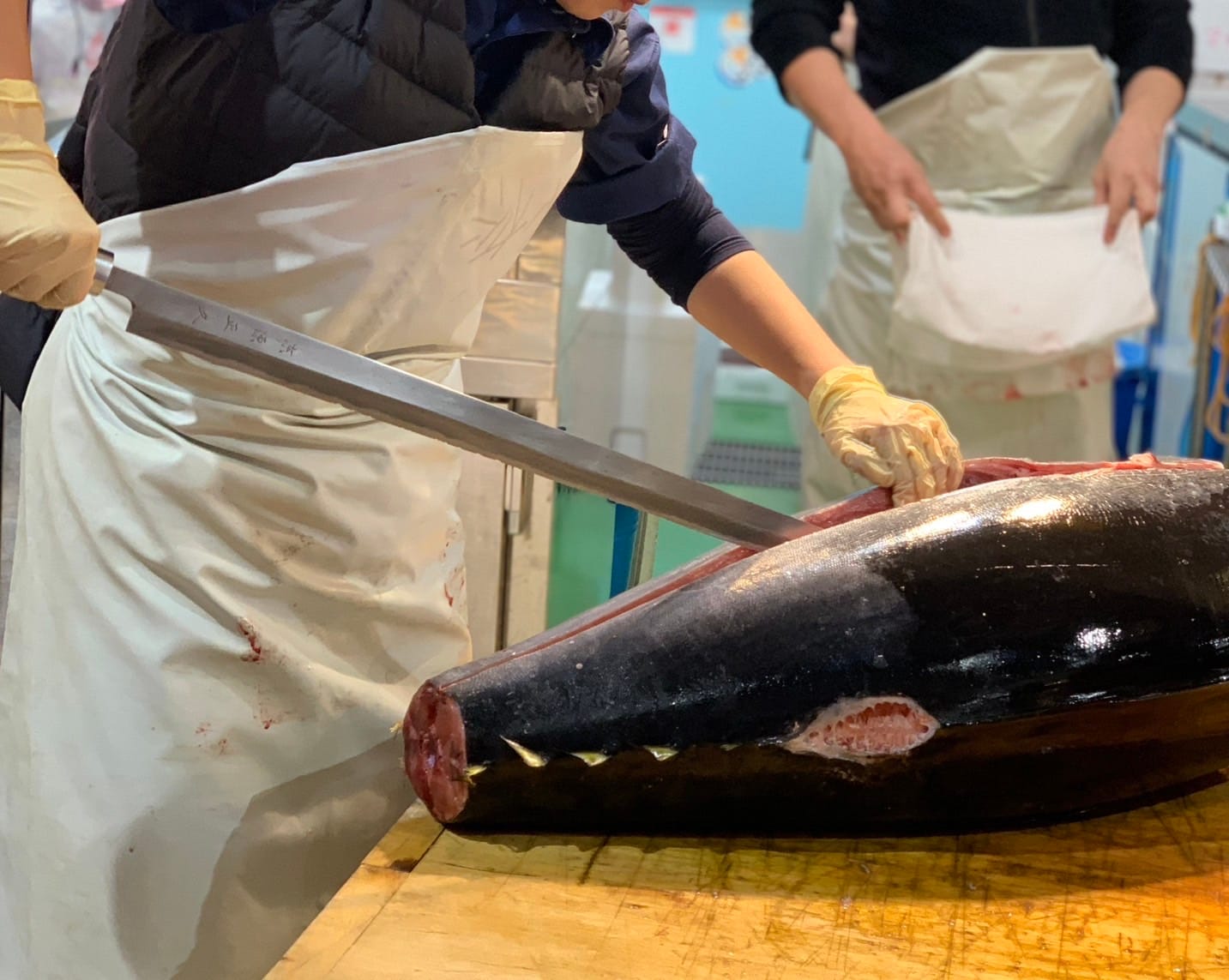 A chef breaking down a large tuna