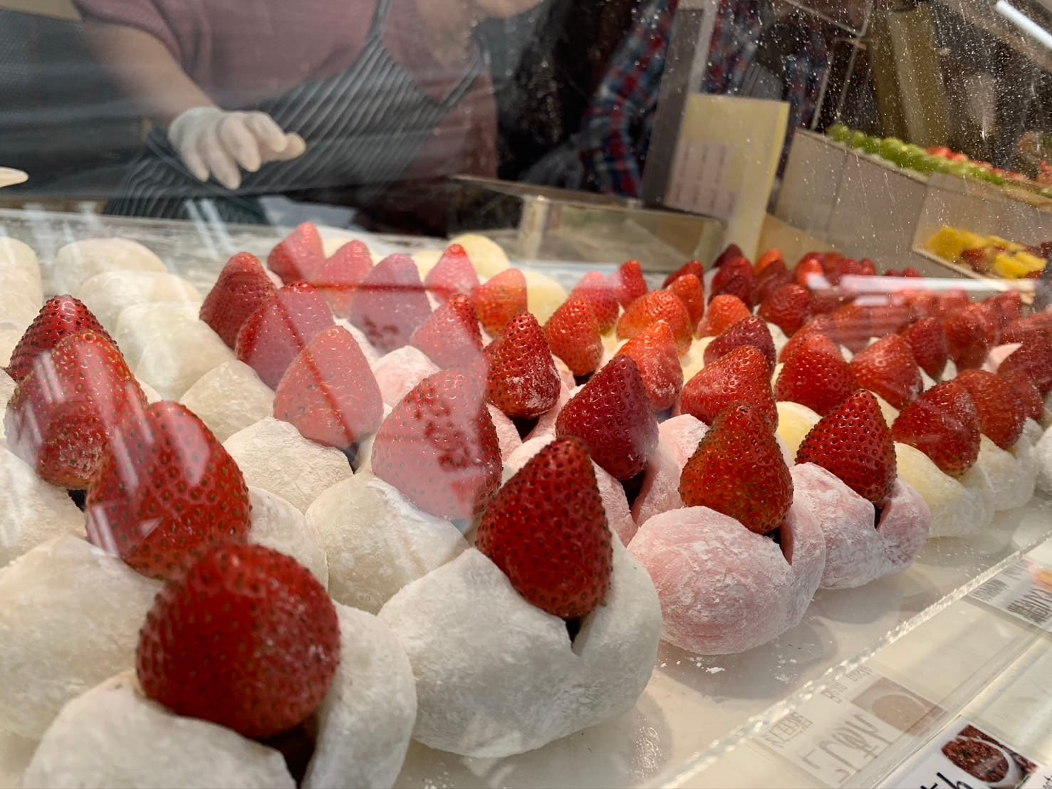 A variety of strawberry daifuku arranged at a street vendor