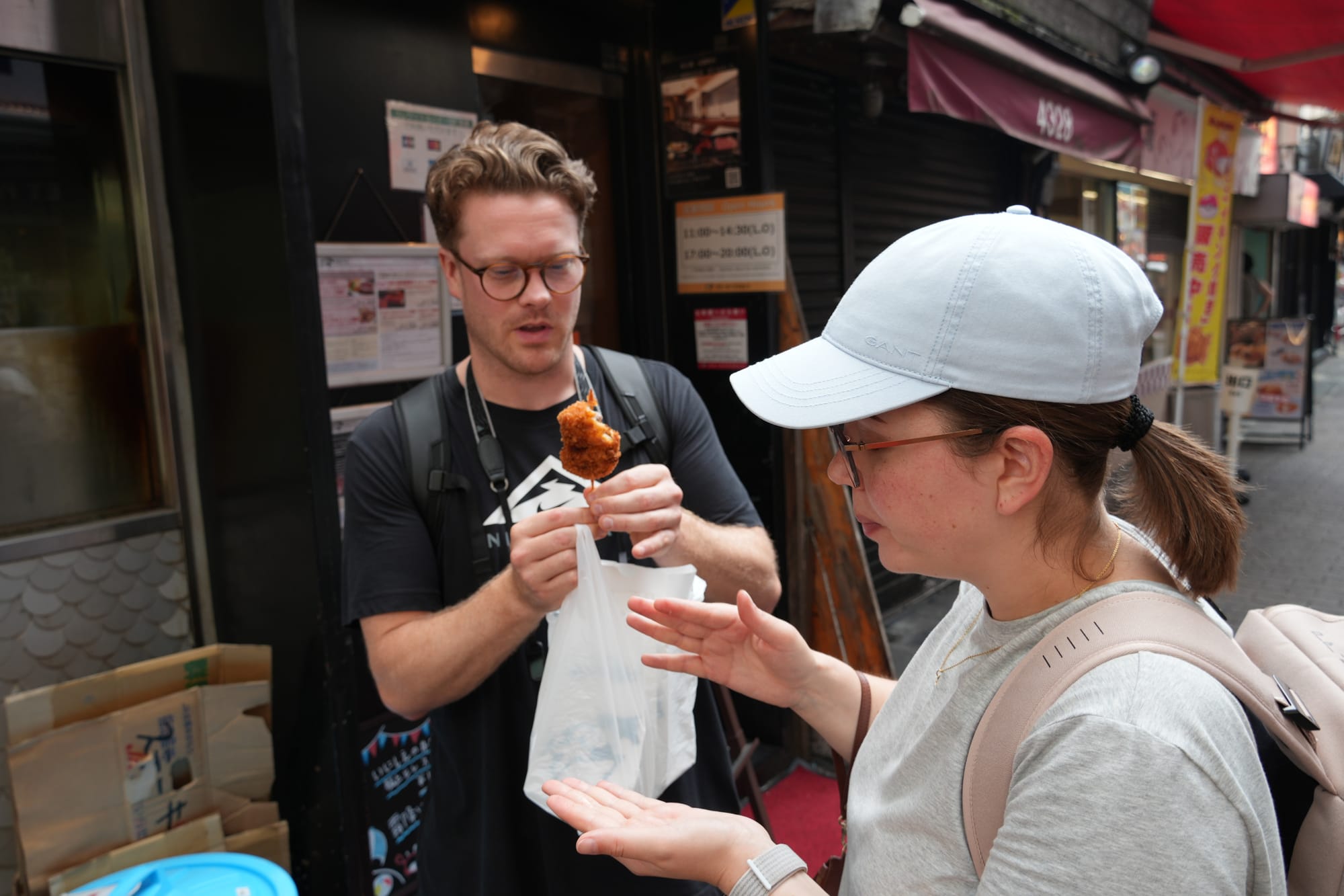 A couple eating a skewer on the streets of Tokyo