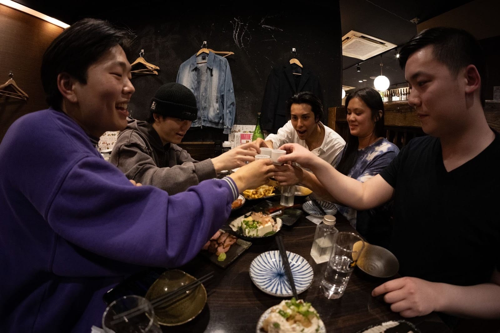 Guides and guests toasting over delicious food during one of TOMOGO!'s Japan bar-hopping tours