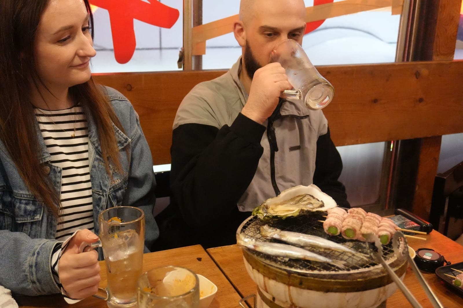 Guests looking at their dinner during a TOMOGO! bar-hopping tour in Tokyo