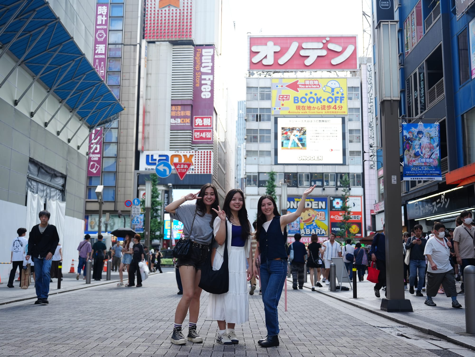 A tour guide poses with a group of friends in Akihabara