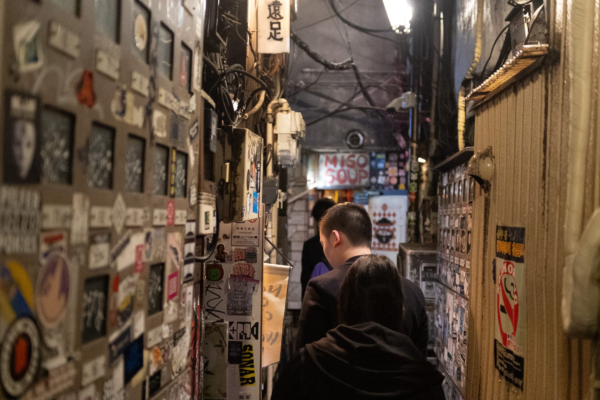 A couple walking through a narrow alley in Shinjuku's Golden Gai