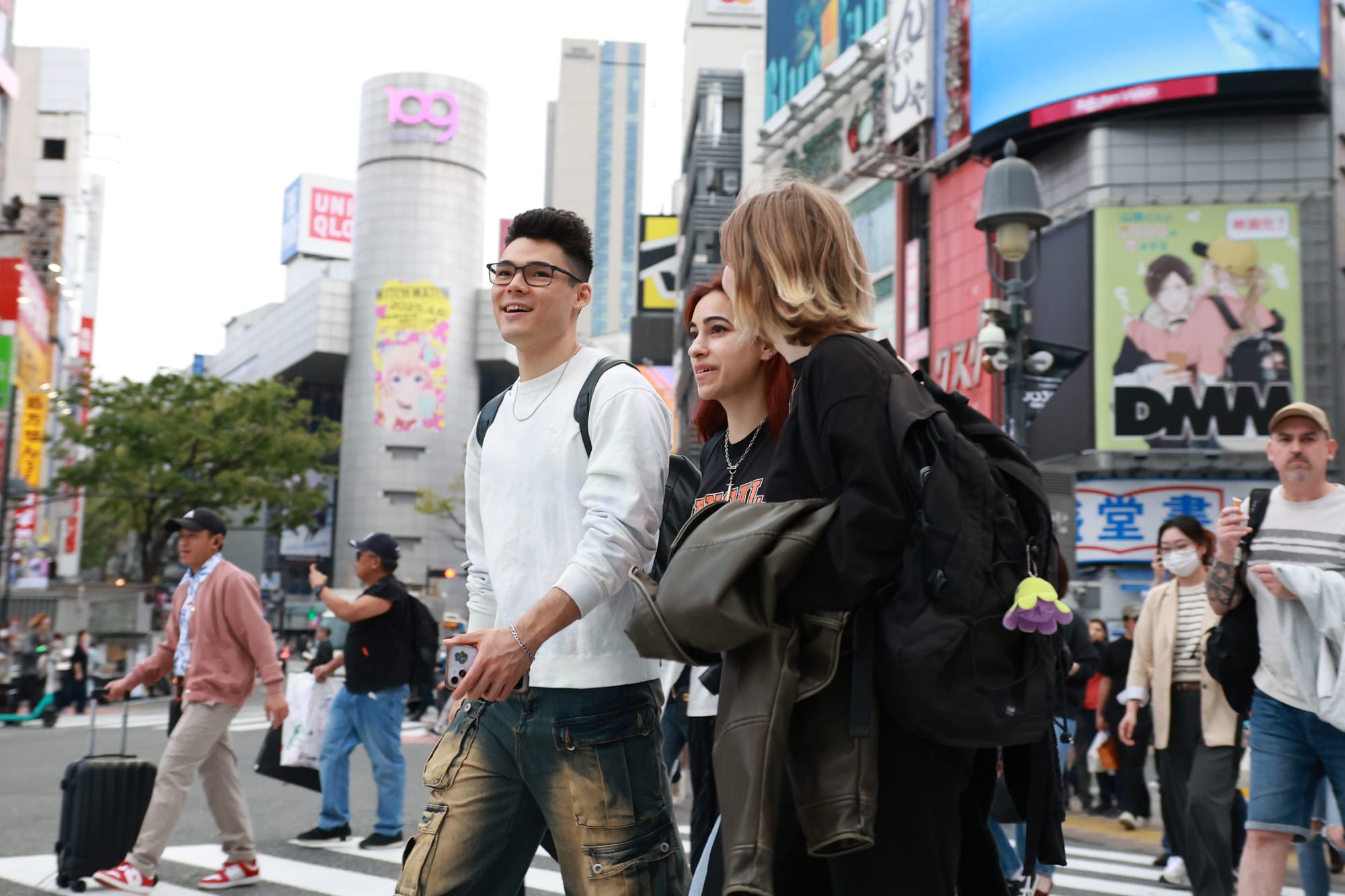 A Japanese tour guide walks a group of friends through Shibuya scramble crossing