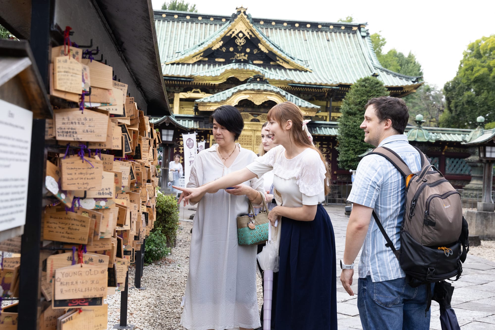 A Japanese tour guide shows a group of friends around a shrine