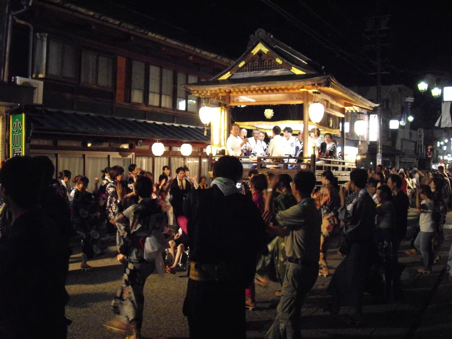 A parade of traditional floats at night at a summer festival in Tokyo, Japan