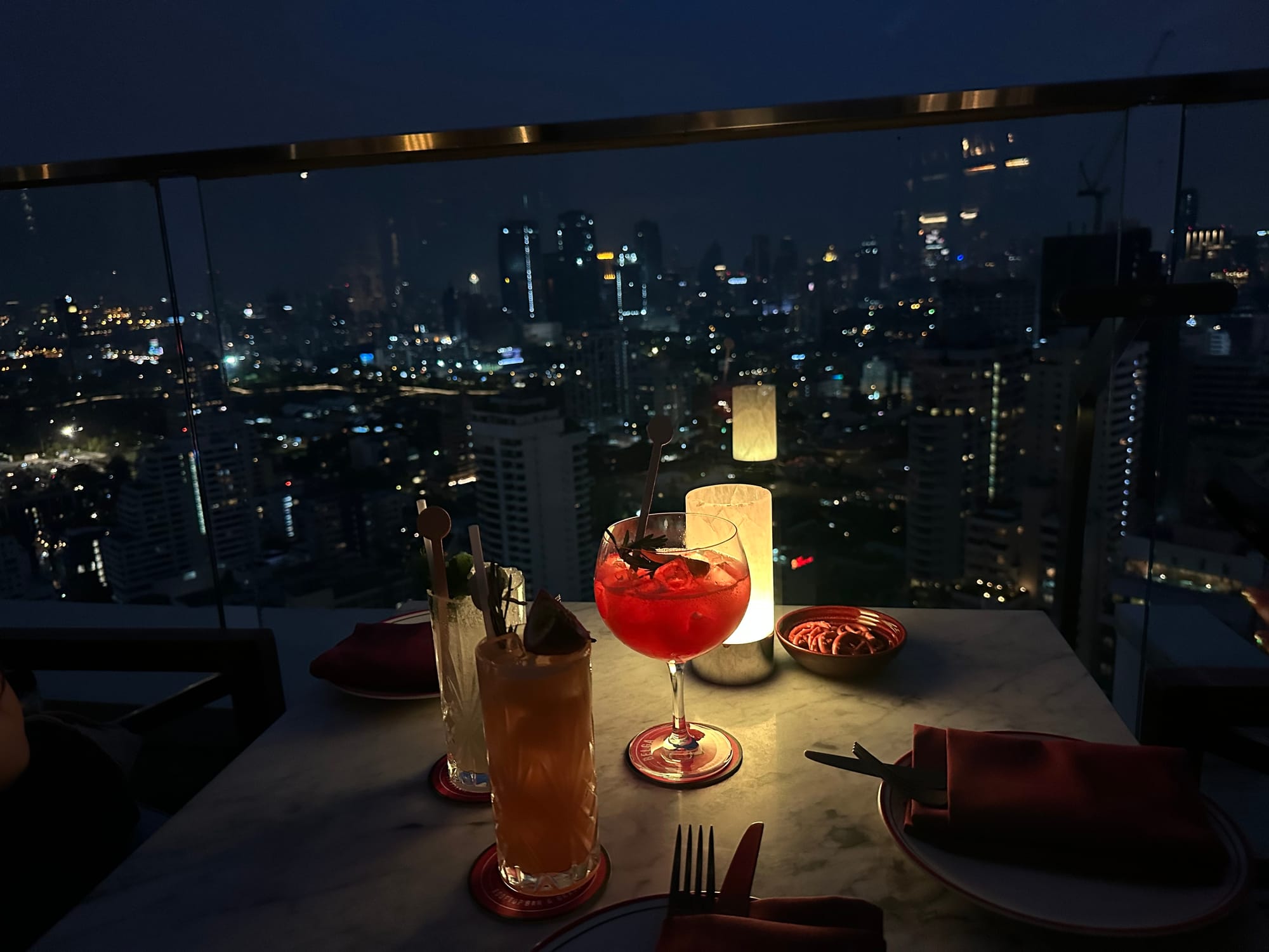 A table at a rooftop bar overlooking Tokyo's skyline at night