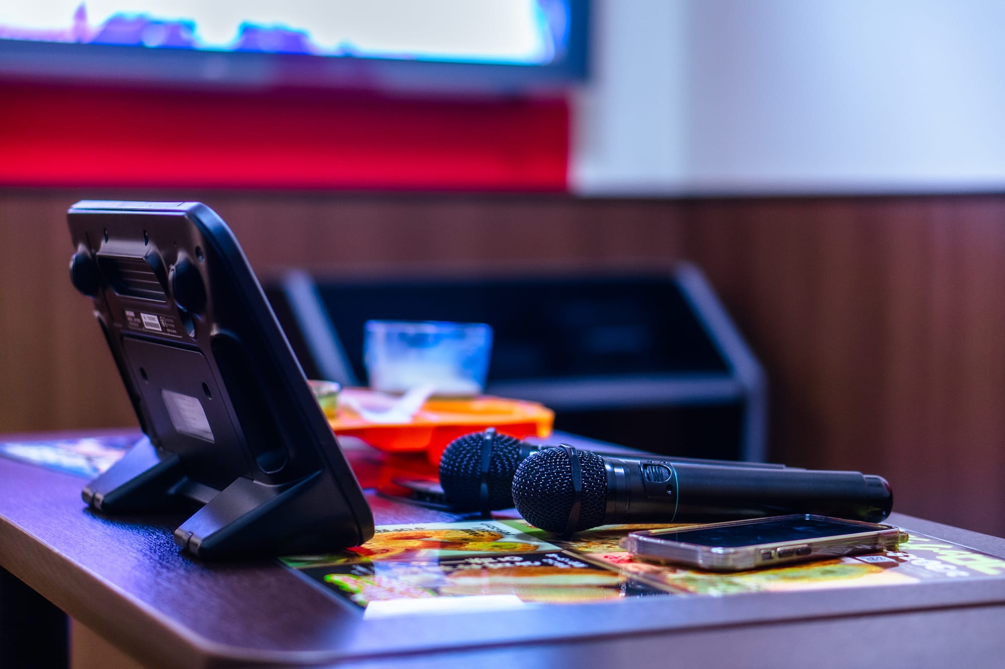 A karaoke booth in Japan with a tablet and two mics laying on a table