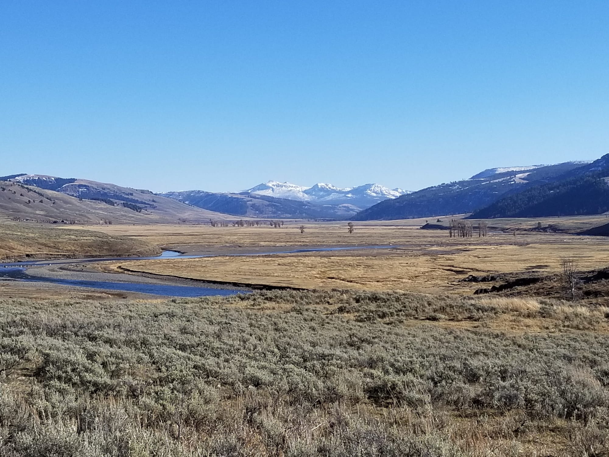 broad valley with mountains in background and river meandering through middle
