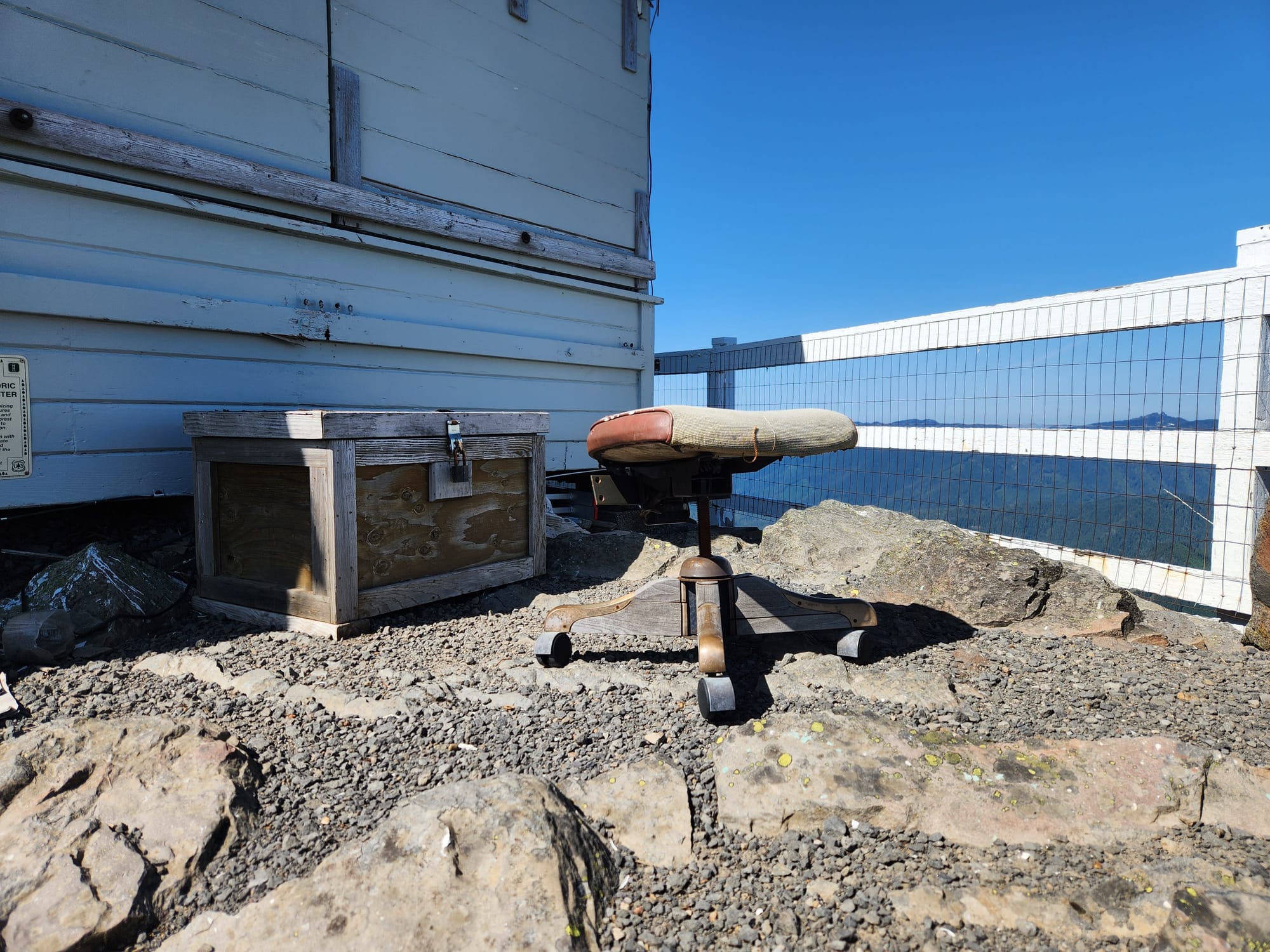 office chair without a back, a box, white fire lookout and railing