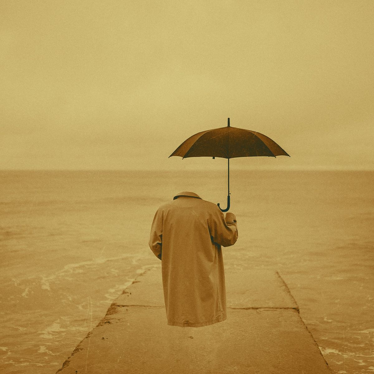 Invisible human wearing a trench coat and holding an umbrella standing at the edge of ocean. 