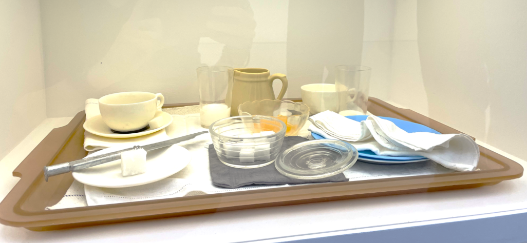 A glass case with dishes and utensils

AI-generated content may be incorrect.