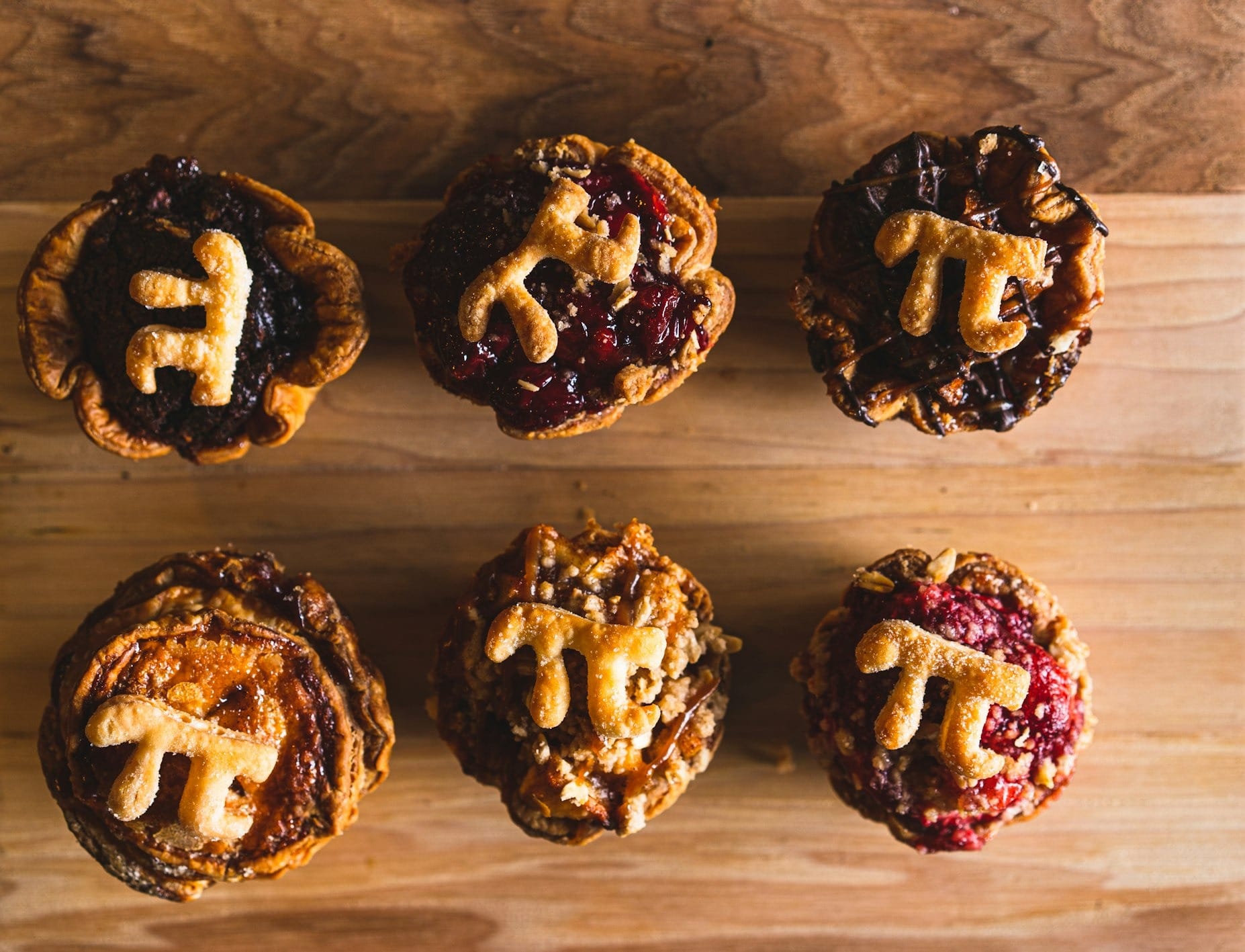 six chocolate cupcakes on brown wooden table