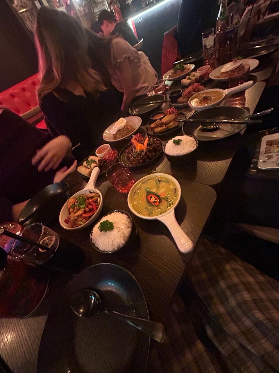 Plates of food laid out on multiple tables at Mangosteen.