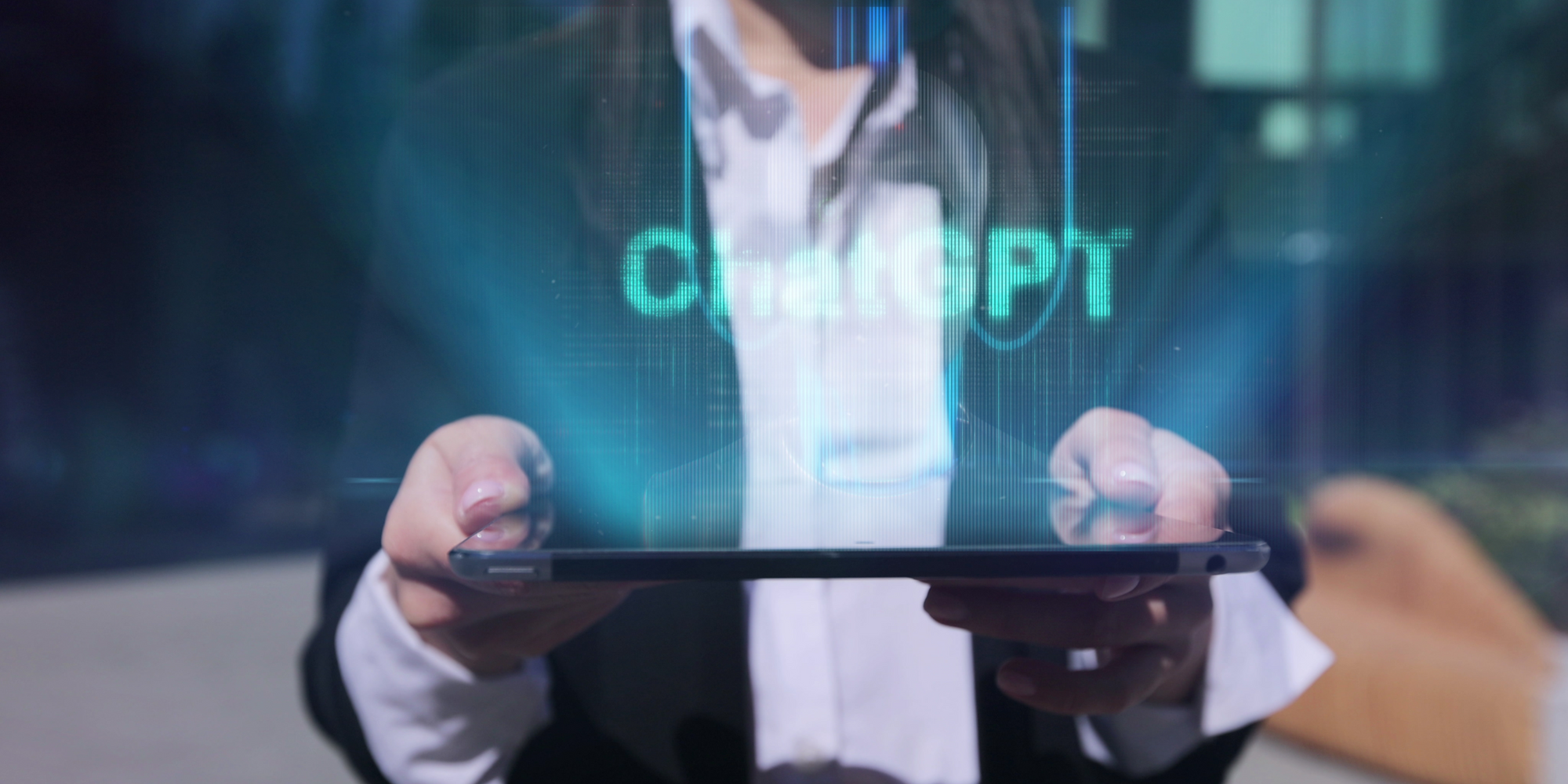 Na imagem: pessoa de terno ergue o tablet com o título Chat GPT logo acima da tela 