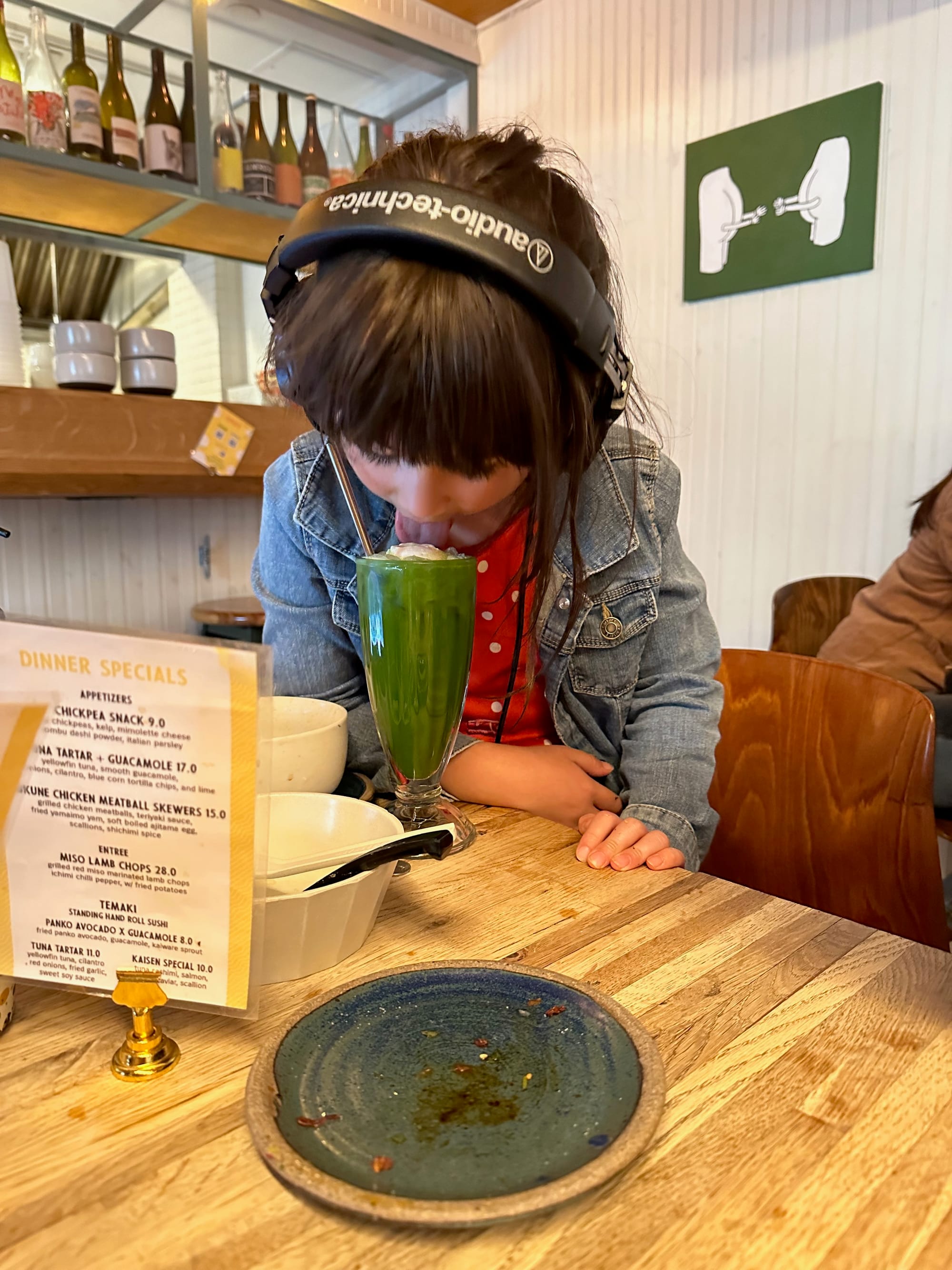 Our daughter face-down in matcha(?) drink a few years ago at Takumen LIC
