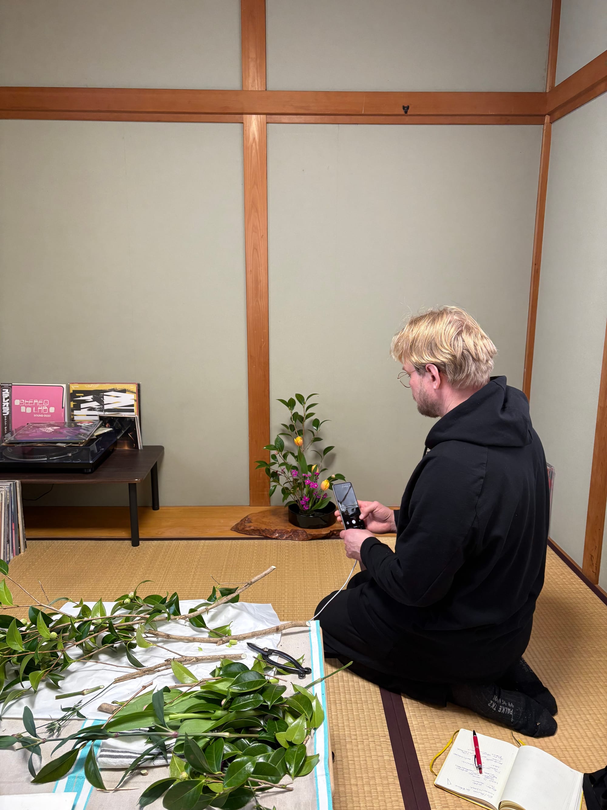 A HanaYou studio guest takes photos of their ikebana arrangement
