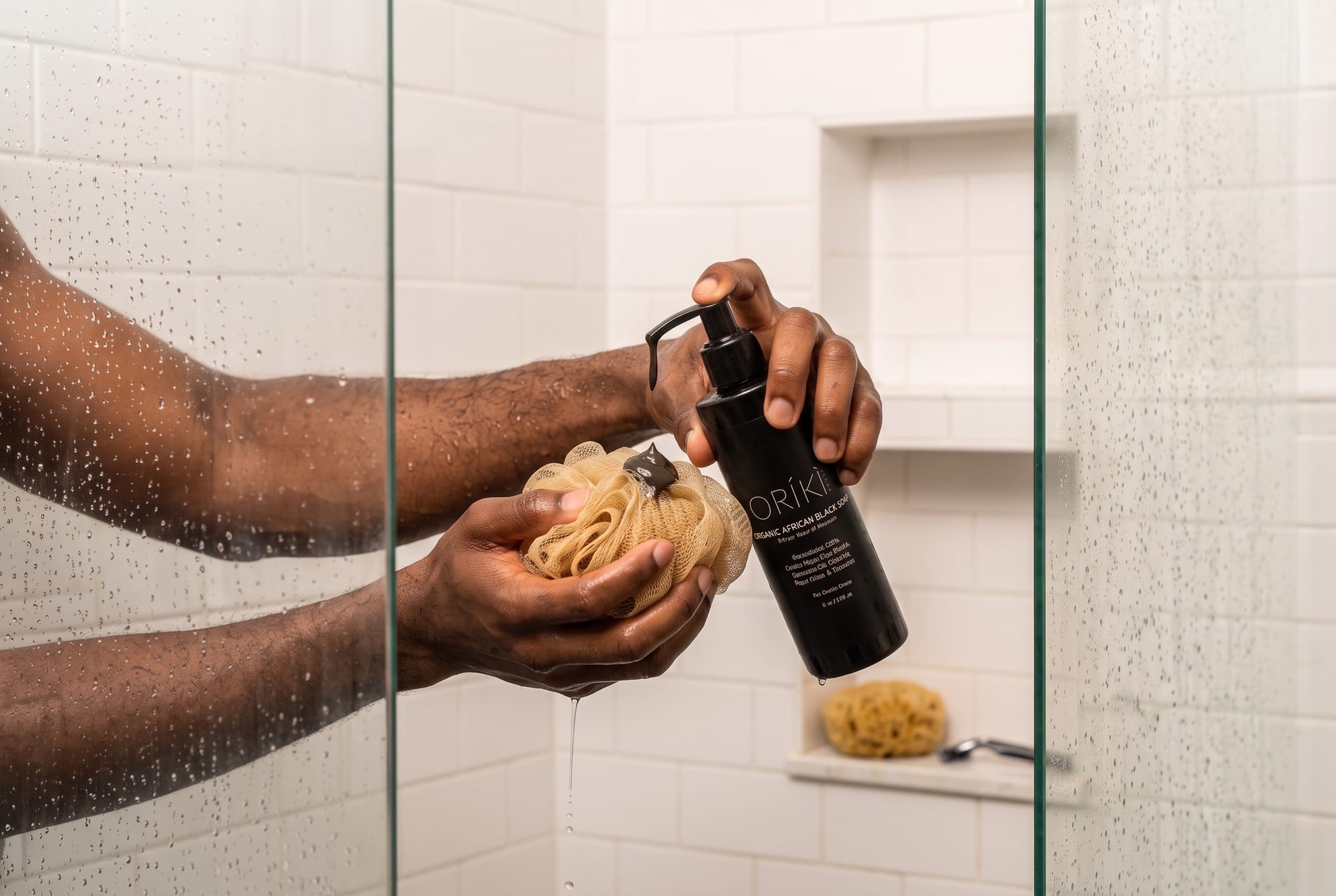 Man applying African Black Soap on Sponge