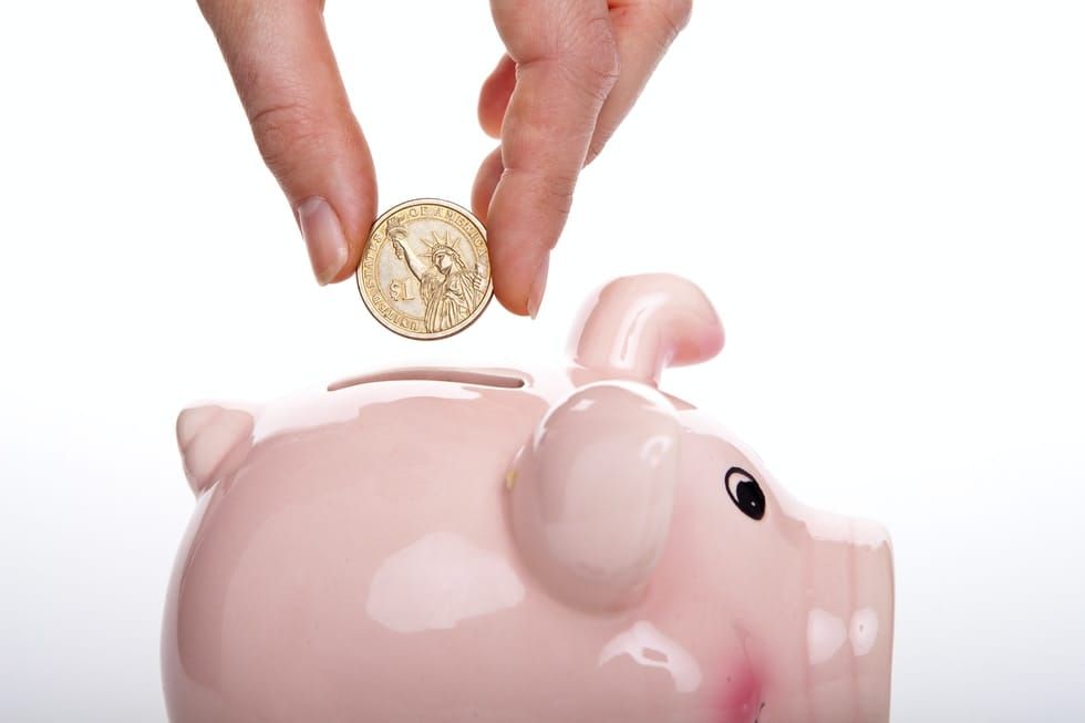 silver round coin on white ceramic pig coin bank