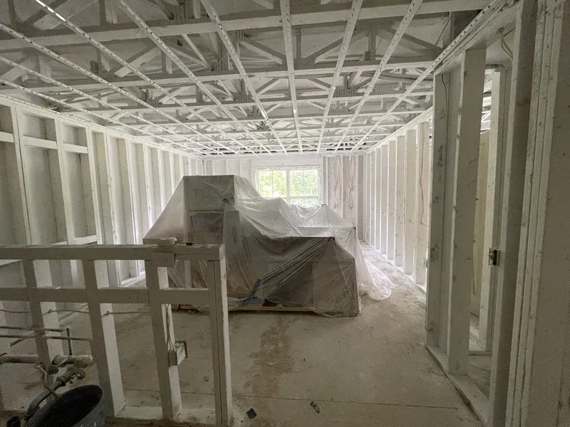 interior of an apartment stripped to studs and painted white