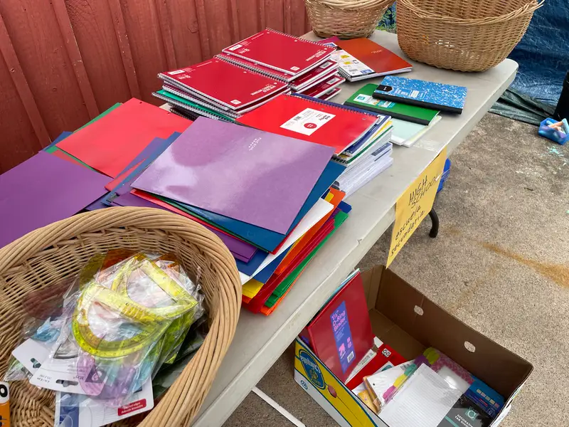 a table displaying folders, notebooks, rulers, and other school supplies